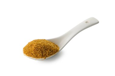 Traditional Svaneti salt blend presented in a white ceramic spoon on pure white background. The aromatic Georgian seasoning mixture creates an appealing culinary composition.