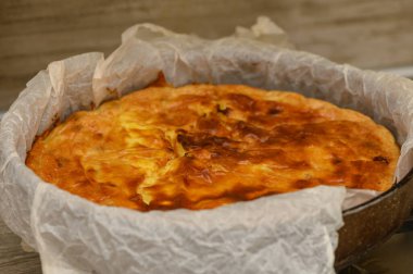 Golden-brown cottage cheese casserole with plump raisins, freshly removed from the oven. The dessert maintains a delicate texture and appetizing appearance, perfect for tea.