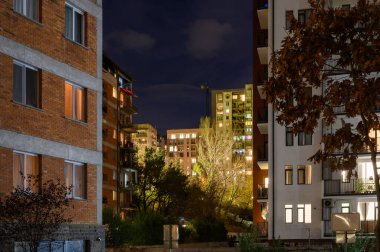 Uyuyan bir şehrin sessiz ve sakin bir sahnesi. Yüzlerce pencere takım yıldızları gibi parıldıyor. Karanlık gökyüzüne karşı bir şablon oluşturuyor ve siluetler oluşturuyor..