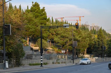 Bereketli ağaçlar ve geleneksel Gürcistan taşlarının duvarları ya da terasları ile çerçevelenmiş bir Tiflis arazisinde dolambaçlı bir yol ya da patika. Doğal yeşillikle ahenkli bir tepede kırsal duvarcılığı birleştirir..