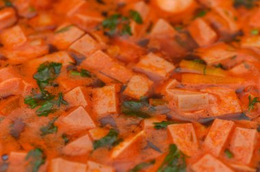 Yumuşak mercimek ve dilimlenmiş sosisle dolu zengin, doyurucu bir domates çorbası. Detaylı bir çekimde ele geçirildi. Bu sağlıklı yemeğin dokusunu, canlı rengini ve rahatlatıcı cazibesini gösterir..