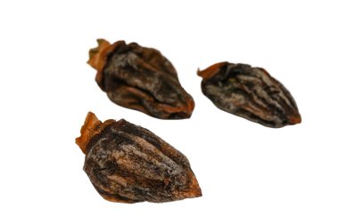 Temiz beyaz bir arkaplana yerleştirilmiş üç doğal kurutulmuş, tatlı hurma. Bu geleneksel kurutulmuş meyvenin buruşuk dokusunu, koyu kehribar rengini ve sağlıklı cazibesini vurgular.