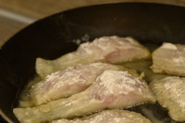 Taze tilapia parçaları sıcak bir tavada cızırdıyor, çıtır çıtır kenarlı, baştan çıkarıcı bir altın kahverengiye dönüşüyor. Görsel ve aromatik cazibeyle dolu basit, besleyici bir yemek.. 