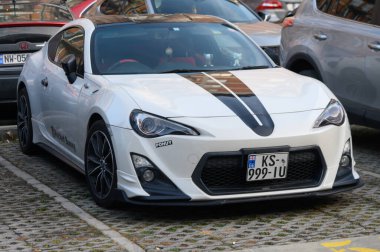 Tiflis, Gürcistan 12.11.2025 Özel üretim Toyota GT86 Blackline altın saat boyunca kıyı dağ yolunda hareket halinde. Belirgin siyah aksanlı sınırlı üretim spor araba..