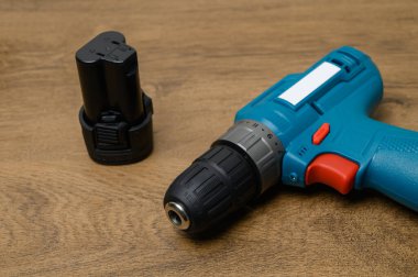 Kablosuz sondaj bataryasının kablosuz akü bölmesi açık, görünür elektrik lensleri desenli ahşap yüzeye yerleştirilmiş. Ayrıntılı teknik araç fotoğrafçılığı.