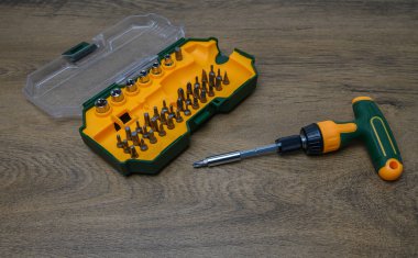 Tahta yüzeyde düzgünce düzenlenmiş 45 farklı parçadan oluşan birinci sınıf tornavida takımı. Sanatçılık ve DIY projeleri için profesyonel araç koleksiyonu fotoğrafçılığı.