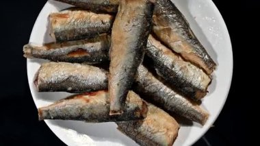 Seramik bir tabakta yavaşça dönen, tepeden tırnağa görüntülenen, küçük ve kızarmış balıklardan oluşan, 4 km 'lik pürüzsüz bir video döngüsü. Klipte iştah açıcı altın-kahverengi kabuk, çıtır çıtır doku vurgulanıyor.