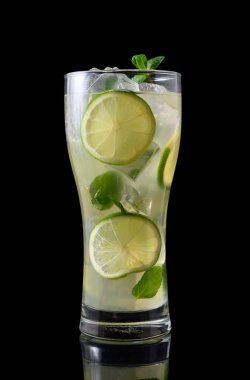 Ezilmiş buz ve taze nane yapraklarıyla dolu, koyu siyah arka planda sunulmuş, viski bardağında klasik bir mojito. Bu basit ama çarpıcı görüntü soğuk ve canlandırıcı öze odaklanır..