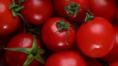 Bir grup olgun, kırmızı vişneli domates mermer bir yüzey üzerinde yavaşça döner. Parlak derileri ve yuvarlak şekilleri canlı, iştah açıcı ve hipnotik bir besin döngüsü yaratır..