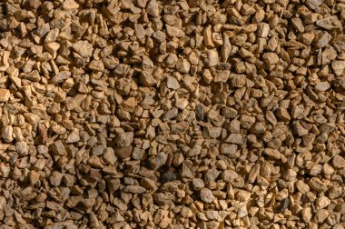 Küçük açılı çakıl ya da ezilmiş taşların yoğun dokusu. İnşaat ve peyzaj işleri için çok yönlü malzeme.