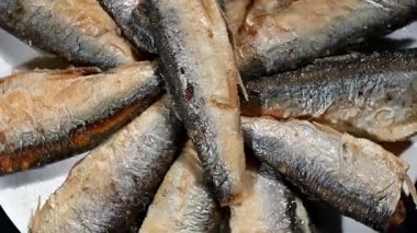 Bir tabakta yavaşça dönen küçük altın balığa yaklaş. Çıtır çıtır bir doku, parlak bir cilt ve yüksek çözünürlüklü detaylı bir yüzey. Deniz ürünleri, aşçılık ve gurme yemek görselleri için mükemmel. Yemek fotoğrafçılığı için kusursuz döngü,