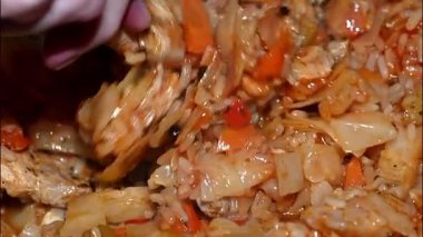 Yumuşak domuz parçaları, beyaz pirinç, havuç ve zengin domates soslu soğan ile yapılan ev usulü lahana güveci. Dökme demir tavada yavaşça pişirme, yumuşak karamelize doku, aromatik buhar yükselişi. Kırsal Doğu Avrupa konforlu yiyecekler, aile