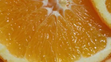Taze dilimlenmiş sulu portakallar bir daire şeklinde dizilmiş ve bir pikapta yavaşça dönüyorlar. Görünür hamurlu ve desenli canlı turunçgillerden yakın çekim. Sağlıklı yemek için mükemmel.,