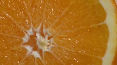 Olgun turuncu tekerlerin yavaş çekimde eski ahşap bir yüzey üzerinde yavaşça dönmeleri. Doğal güneş ışığı yumuşak gölgeler yaratır ve şeffaf hamuru ön plana çıkarır..