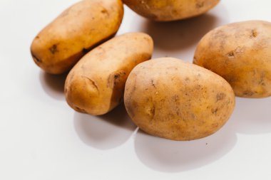 Beyaz arka planda taze çiğ patates.