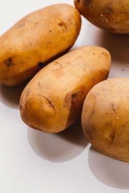 Beyaz arka planda taze çiğ patates.