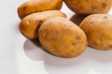 Beyaz arka planda taze çiğ patates.