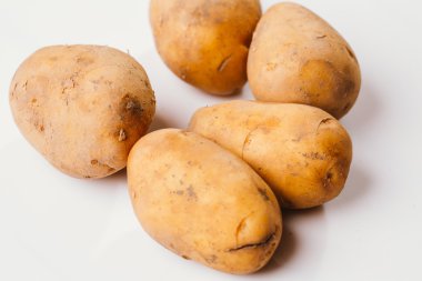 Beyaz arka planda taze çiğ patates.