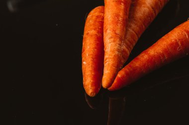 Siyah bir zemin üzerine taze çiğ havuç