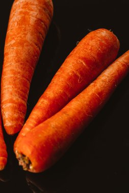 Siyah bir zemin üzerine taze çiğ havuç