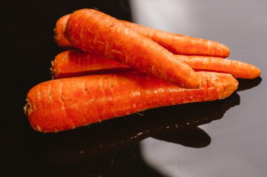 Siyah bir zemin üzerine taze çiğ havuç