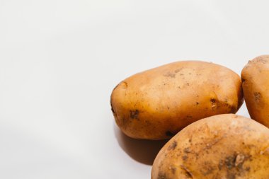 Beyaz arka planda taze çiğ patates.