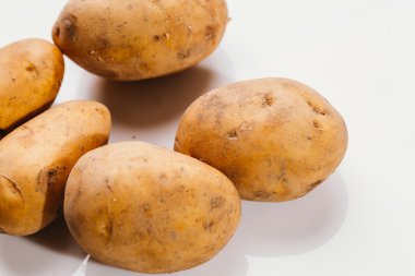 Beyaz arka planda taze çiğ patates.