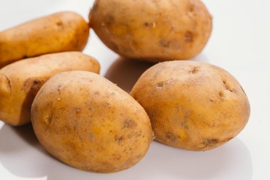 Beyaz arka planda taze çiğ patates.