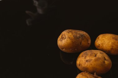 Siyah bir zemin üzerine taze Çiğ patates