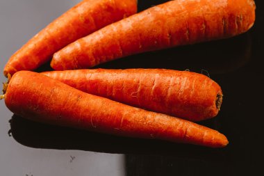 Siyah bir zemin üzerine taze çiğ havuç