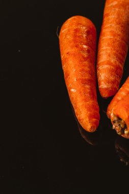 Siyah bir zemin üzerine taze çiğ havuç