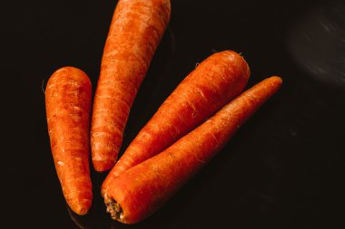 Siyah bir zemin üzerine taze çiğ havuç