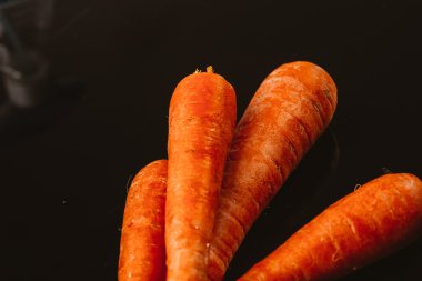 Siyah bir zemin üzerine taze çiğ havuç