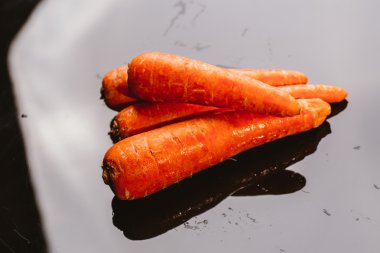 Siyah bir zemin üzerine taze çiğ havuç