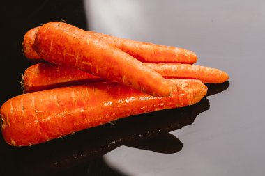 Siyah bir zemin üzerine taze çiğ havuç