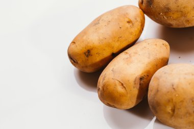 Beyaz arka planda taze çiğ patates.