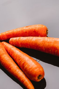 Siyah bir zemin üzerine taze çiğ havuç