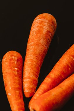 Siyah bir zemin üzerine taze çiğ havuç