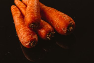 Siyah bir zemin üzerine taze çiğ havuç