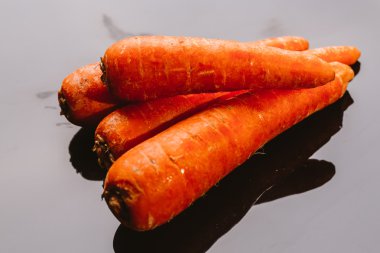 Siyah bir zemin üzerine taze çiğ havuç