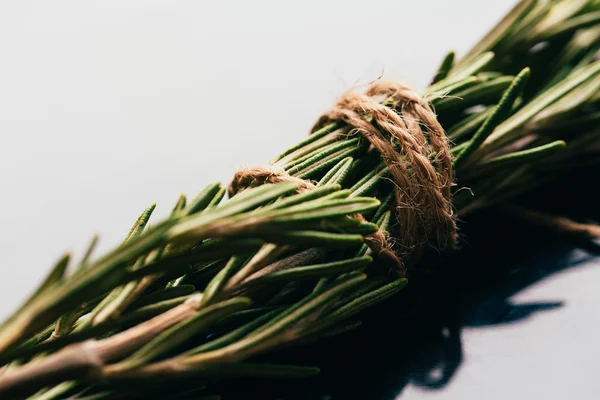 Bunt av kvistar rosmarin bundna med sträng på en mörk spegel bakgrund — Stockfoto