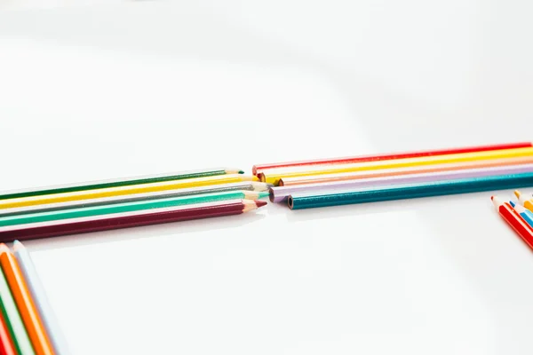 Lápis coloridos em um recipiente no fundo branco — Fotografia de Stock