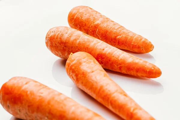 Carottes crues fraîches sur fond blanc — Photo