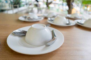 Lokantadaki ahşap bir masada kaşıklarla tepetaklak duran bir sürü beyaz kase var..