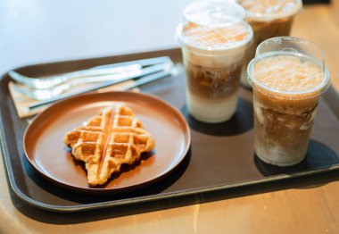 Buzlu kahve içecekleri ve waffle bir kafede tepside servis edilir..