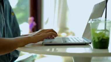 Kadın zarif, modern bir dizüstü bilgisayar üzerinde çalışıyor. Klavyede yazan eller