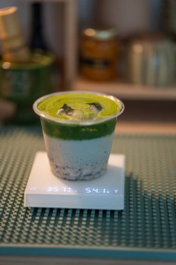 Plastik bardakta muz ve sütle kibrit yeşili çay. Masada organik Japon kibrit aksesuarlarıyla hayat devam ediyor..