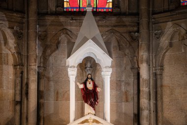 İsa heykeli, tarihi taş katedralindeki beyaz gölgeliğin altında duruyor..