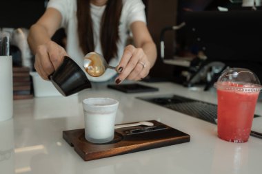 Bardağa soğuk taze süt döken bir kadın baristanın yakın çekimi. Sürecin Kirli Latte Kahve Kremalı Kupasını Yapması