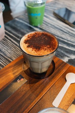 Kahve dükkanının ahşap masasında, yukarıdan bir bardak kapuçino..